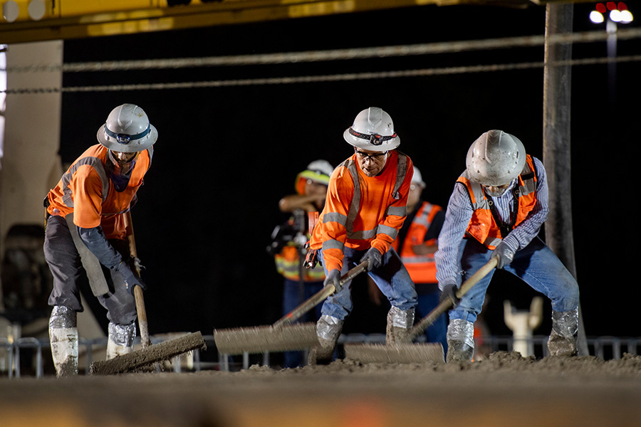 Construction workers spreading concrete