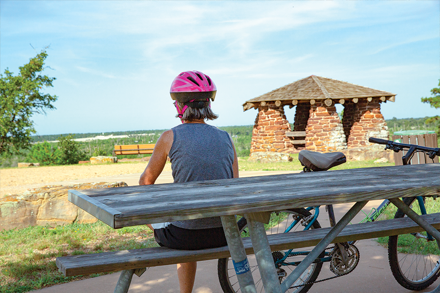 bicyclist resting on bench overlooking scenic view