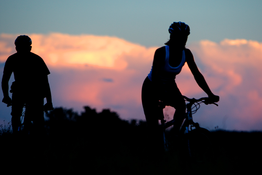 Bicyclists riding at sunset