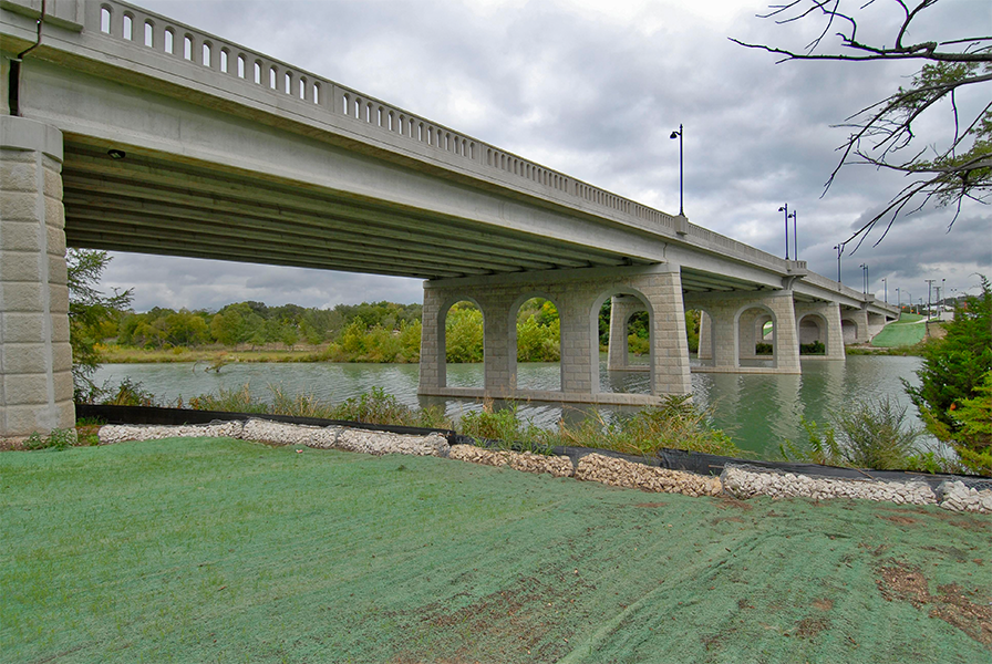 Vista de un puente de carretera que muestra la vegetación después de la siembra