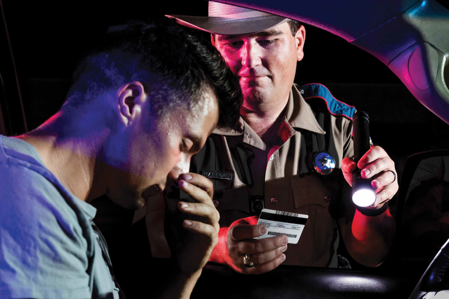 Officer holding driver's license of driver under suspicion of DUI