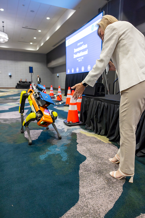 Presentadora, Shelley Row, interactuando con el perro robot de TxDOT, Spot, durante el Texas Innovation Invitational 2026 en Allen, Texas, del 15 al 17 de junio de 2026.