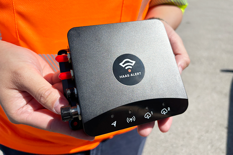 A transponder installed in vehicles to automatically send MOVE OVER OR SLOW DOWN alerts to approaching drivers when emergency warning lights are activated.