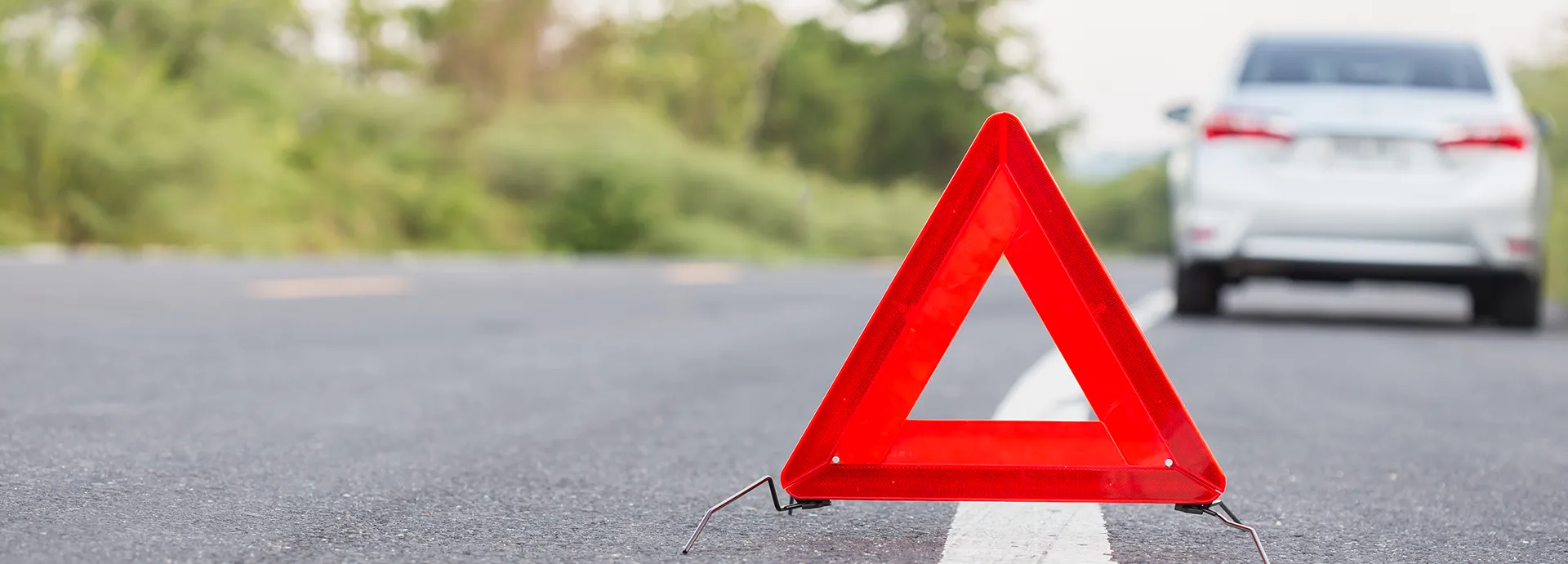 Triangle emergency stop sign behind stopped car