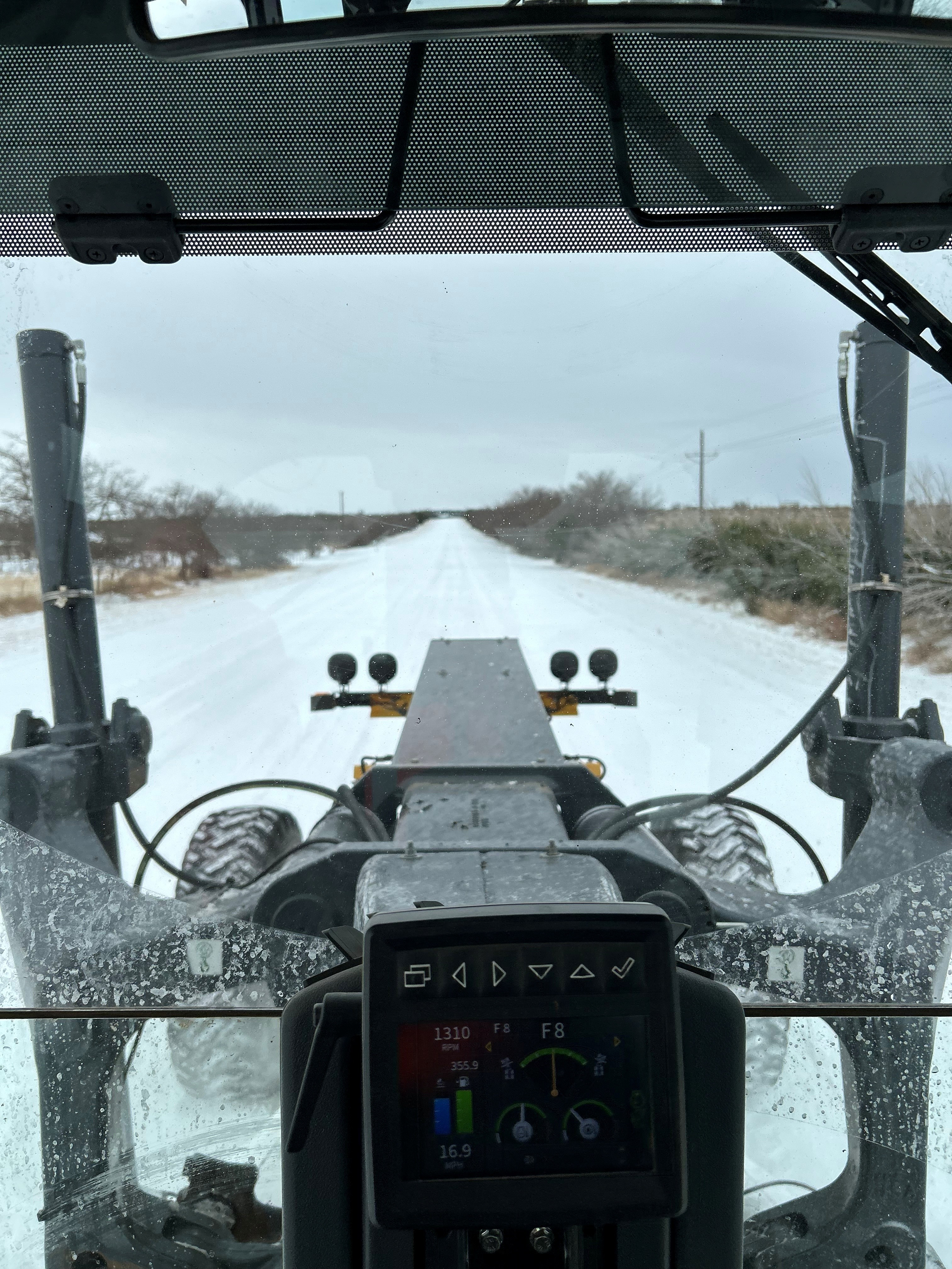 La vista desde detrás del volante de un mantenedor limpiando carreteras en Texas en enero de 2026.