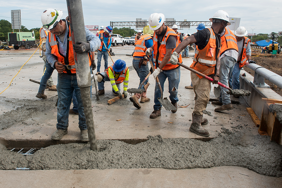 Construction workers lay cement