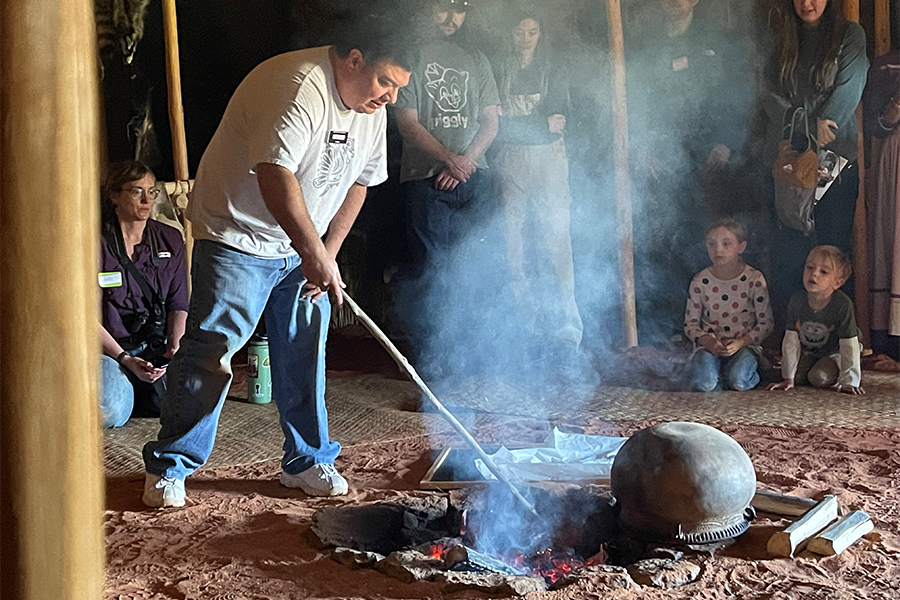 El hombre cuida el fuego de un pozo para cocinar