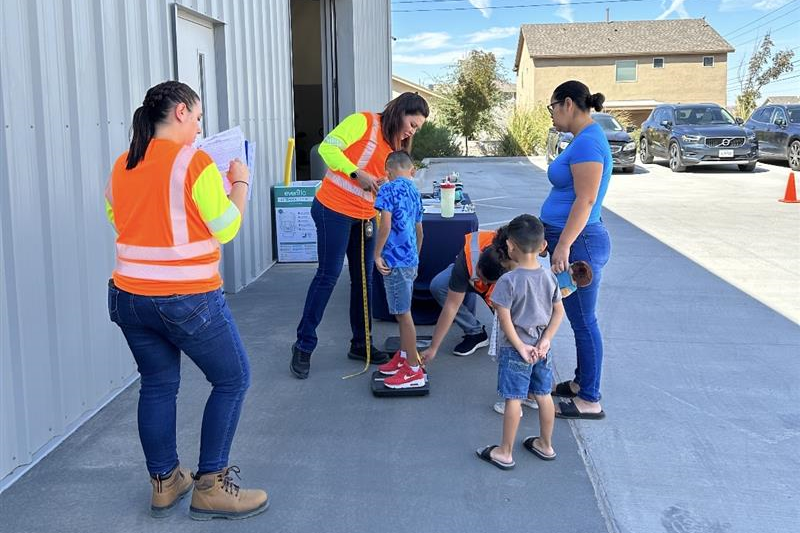 Niños siendo pesados en un evento de asientos de seguridad por trabajadores de TxDOT.