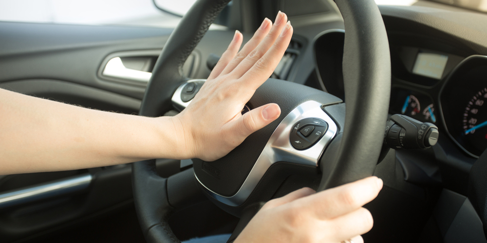 Driver with hand on car horn
