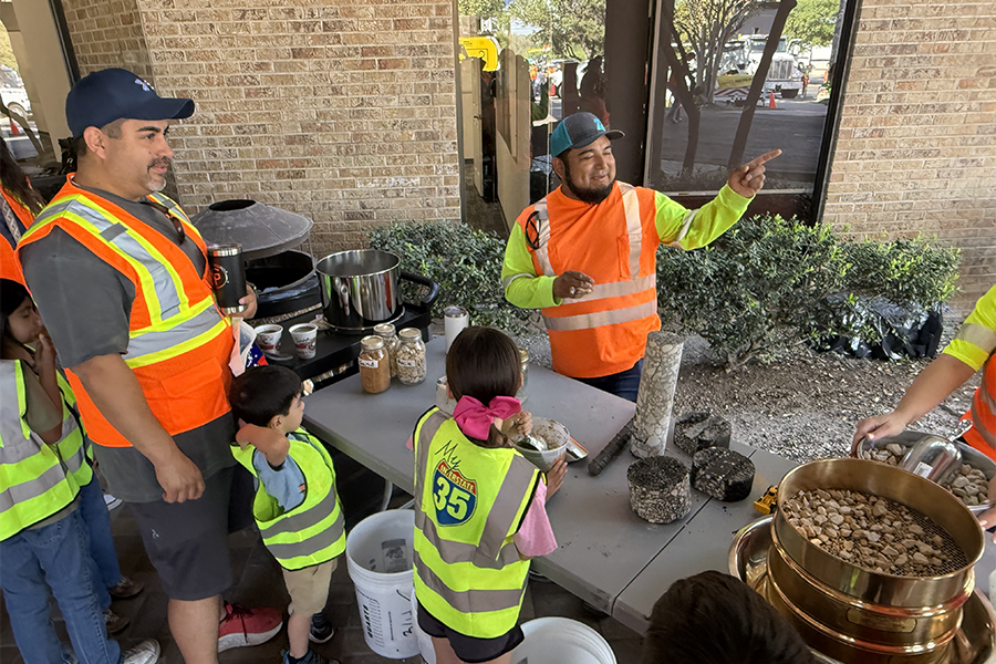 A TXDOT worker shows children materials that go into construction