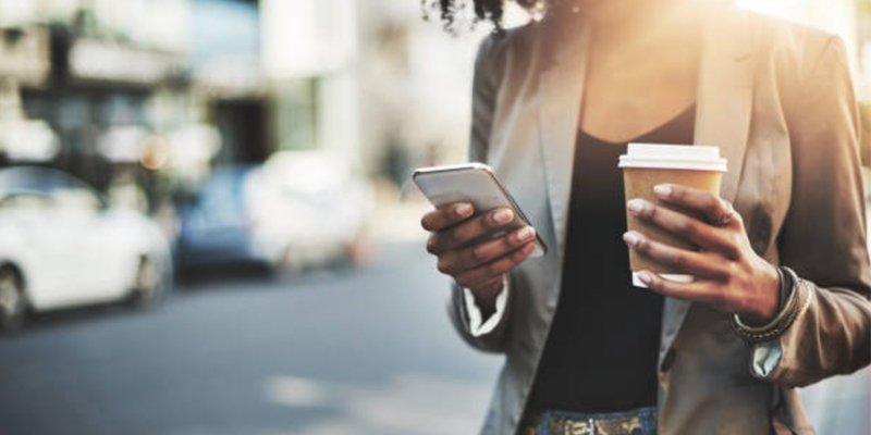 Image of Woman Holding Coffee and Phone