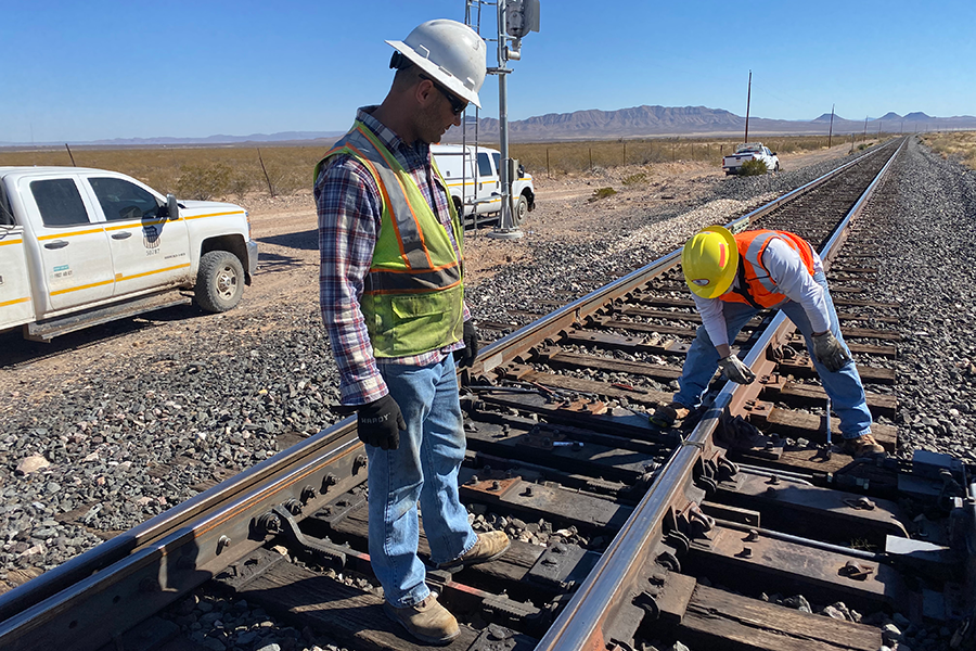 Los trabajadores viales de TxDOT se reunieron frente a los letreros de seguridad vial: Conduzca amigablemente, Realmente detenga significa detenerse y Denos un freno