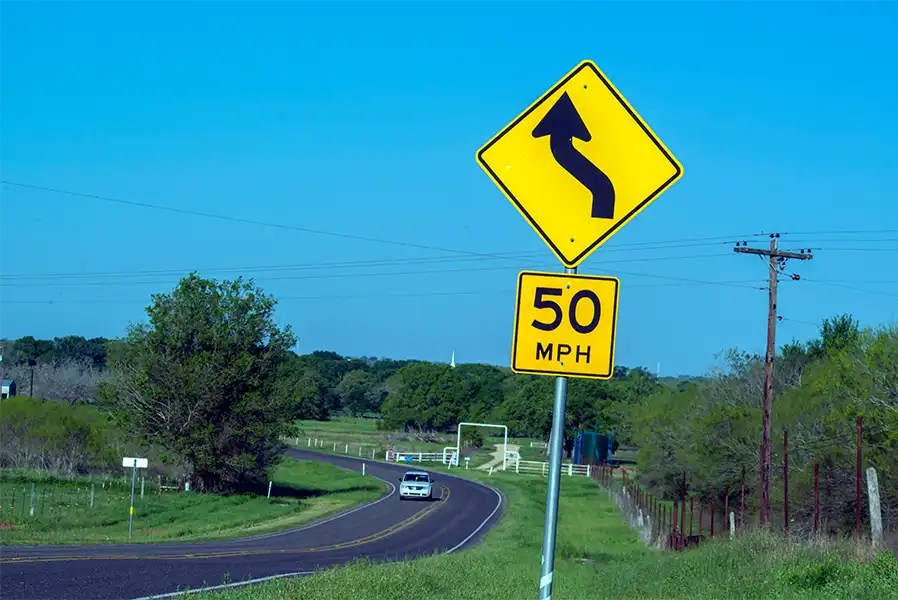 Señal de advertencia en la carretera - curva en la carretera