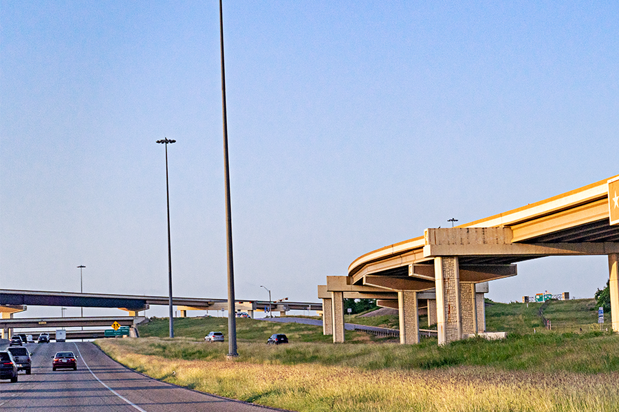 Light poles on roadside and highway over passes