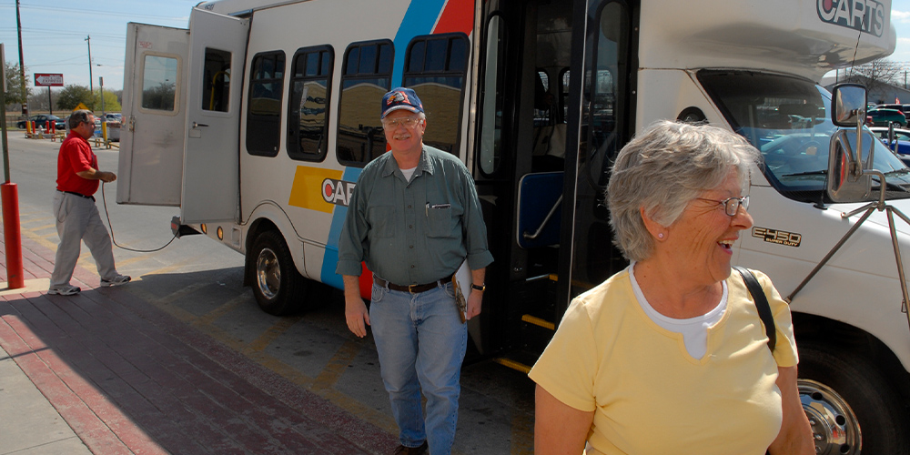 Elderly man and woman depart bus