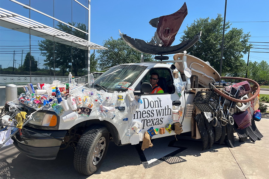 "Don't Mess with Texas" truck with trash attached to vehicle.
