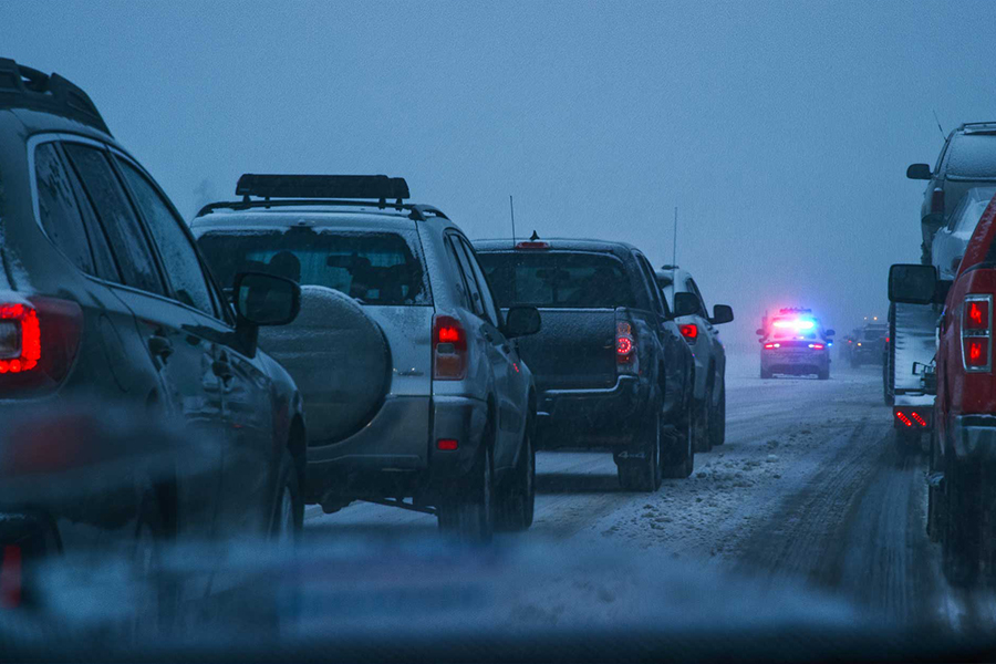 Vehículos en carretera helada detrás del coche de policía