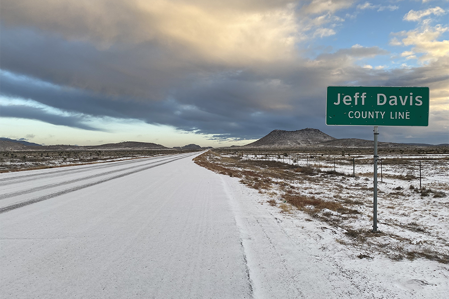 Highway covered by snow with Jeff Davis county line sign.