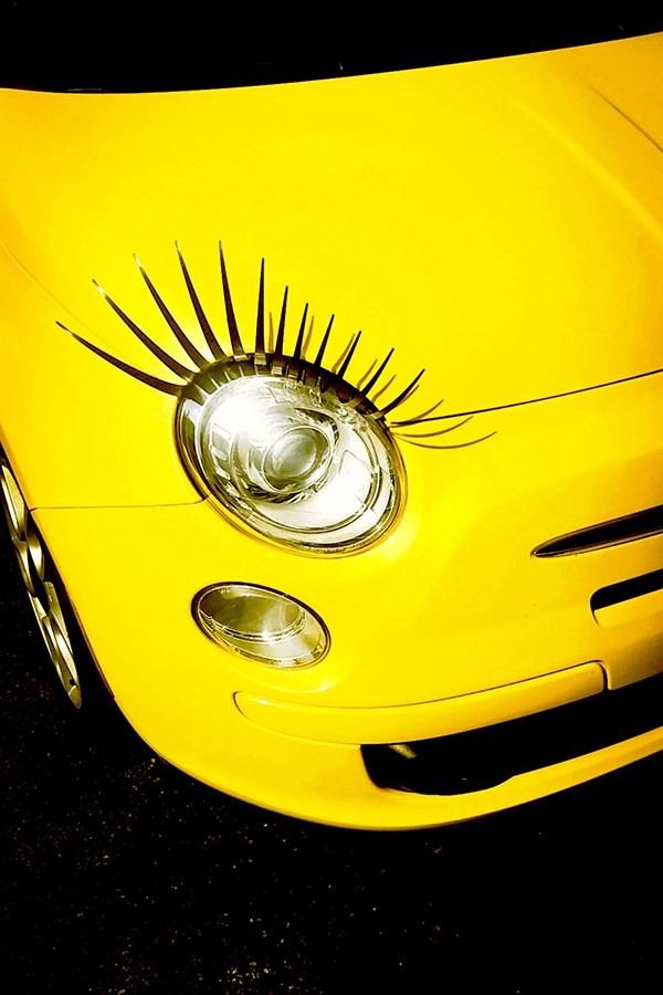 yellow car with eyelashes on headlight