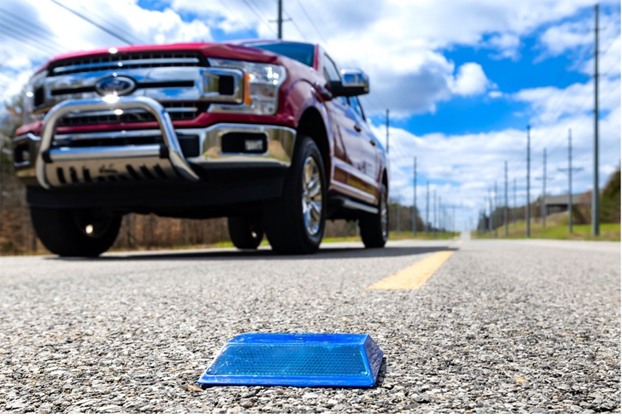 blue pavement marker with truck on road