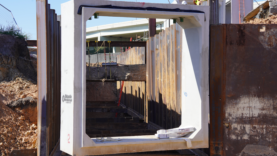 Crane lowers storm sewer box into the ground