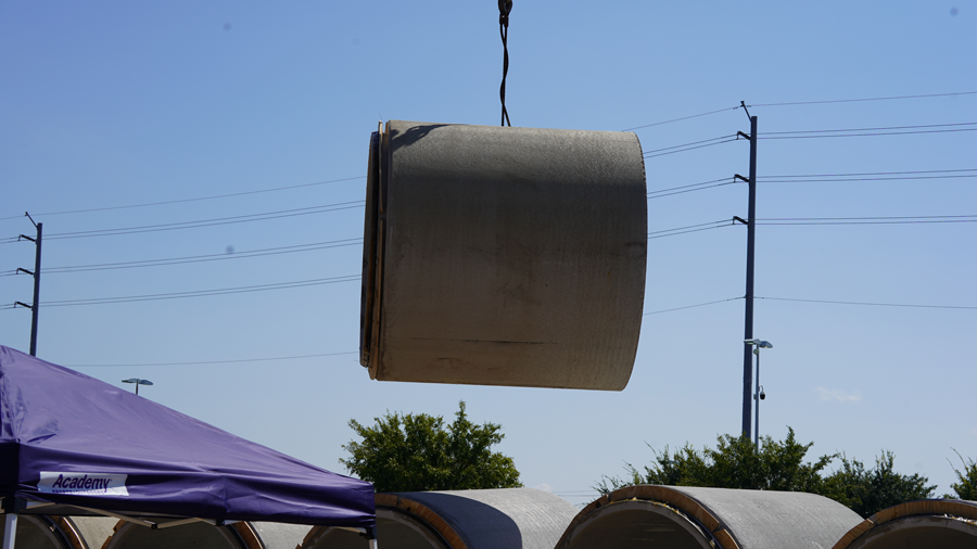  Pipe rises just before crane lowers it into pit underneath Texas Ave