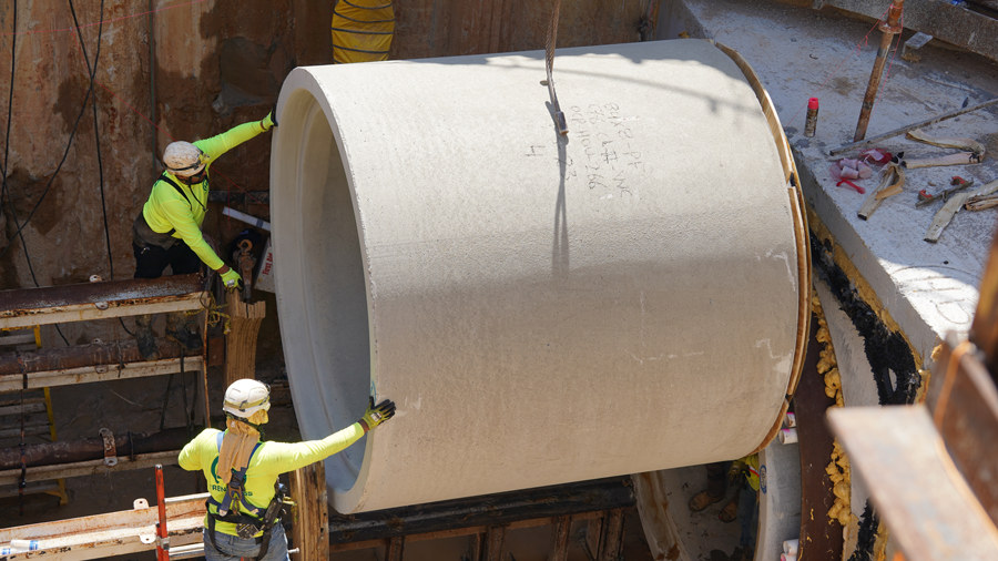Crew places storm sewer pipe into place