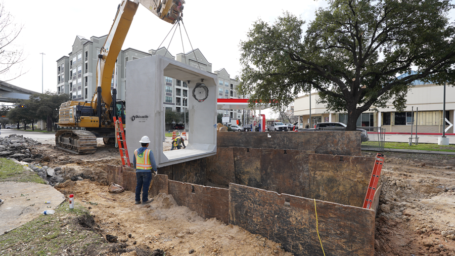 Crews place one of the large boxes into the ground.