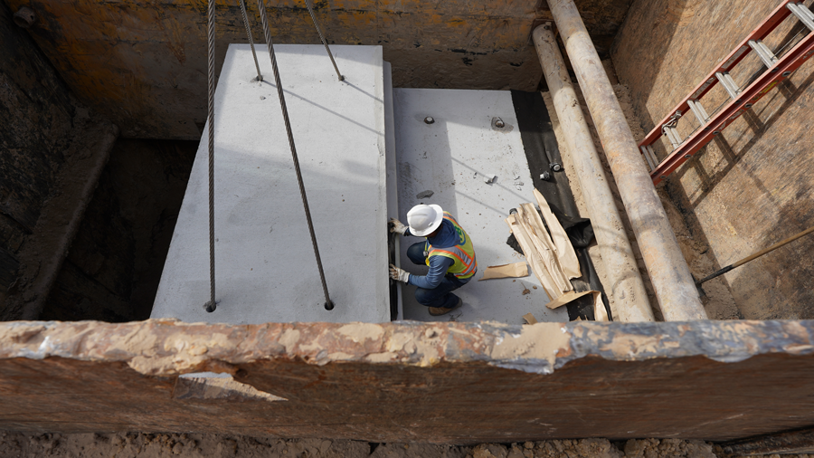 Crew member helps place the box next to one already in the ground