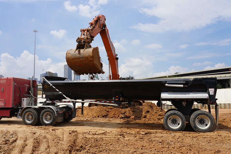 Excavator removes soil from detention pond area