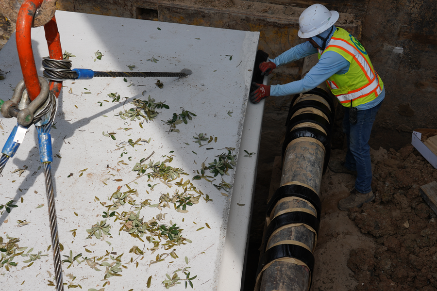 Crew member guides storm sewer box into place