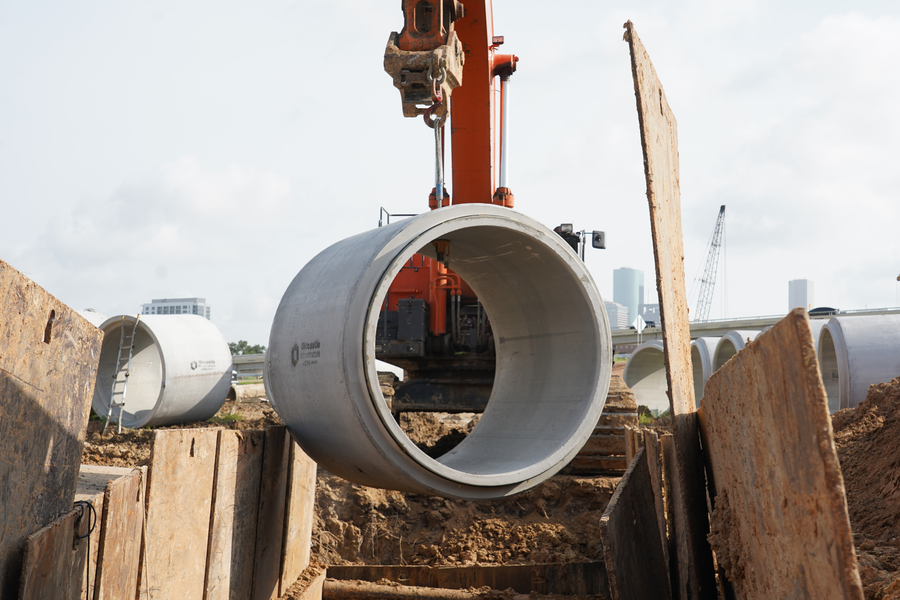 Excavator begins lowering 8-foot diameter storm sewer pipe into the ground near Cleburne  and SH 288