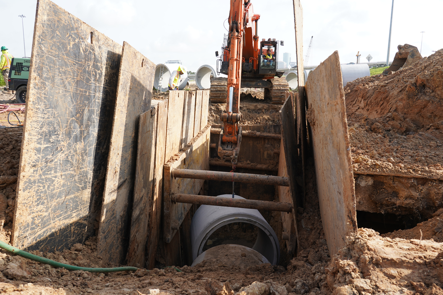Excavator completes lowering of storm sewer pipe