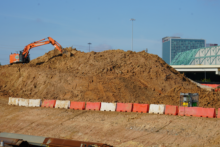 Excavator moving soil at south end of detention pond