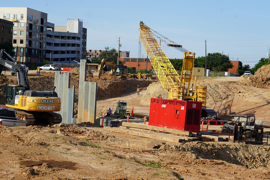 Crews installing metal sheet pilings to stabilize inner part of detention pond