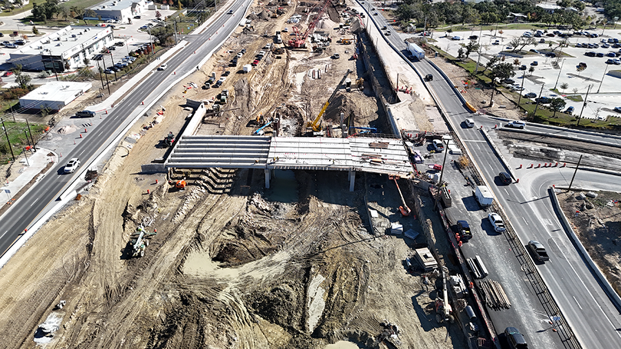 After recently installing beams for the RM 1826 cross-street bridge, Oak Hill Parkway crews begin construction of the deck by placing panels. December 2024
