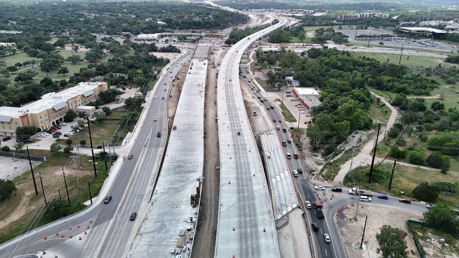 Con el puente del carril principal de la US 290 en dirección oeste que soporta temporalmente el tráfico en dirección este, las cuadrillas de Oak Hill Parkway avanzan en el futuro puente del carril principal de la US 290 en dirección este junto a él.  Recientemente, las cuadrillas vertieron la cubierta de concreto del puente para varios tramos de este puente al este de William Cannon Drive, mientras continúan colocando vigas para los tramos hacia el oeste.  Mayo 2025