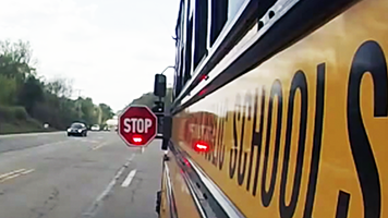 school bus displaying stop sign and flashing rights