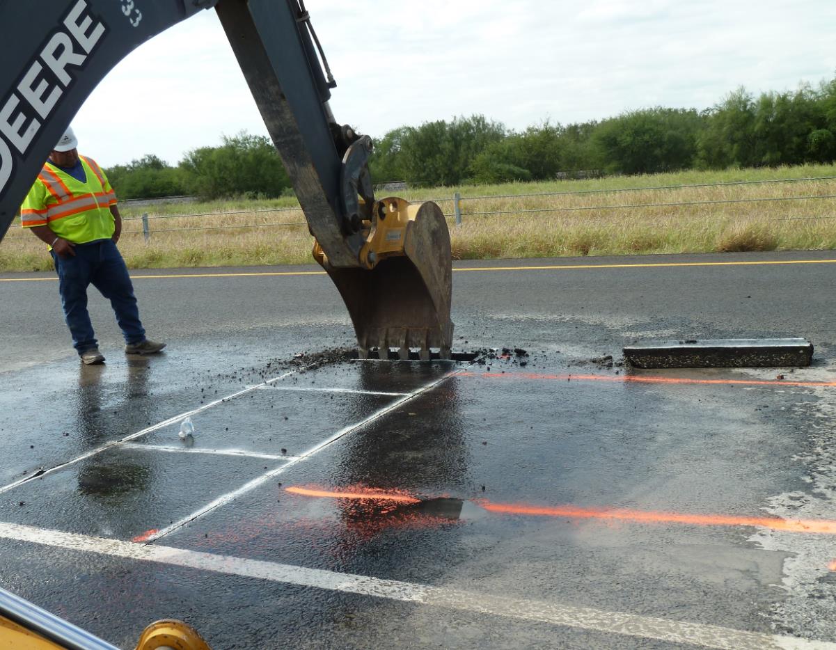Removing hot-mix asphalt (HMA) block withbackhoe. (click in image to see full-size image)