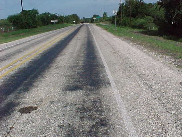 A seal coat pavement surface exhibitingflushing in the wheelpaths. (click in image to see full-size image)