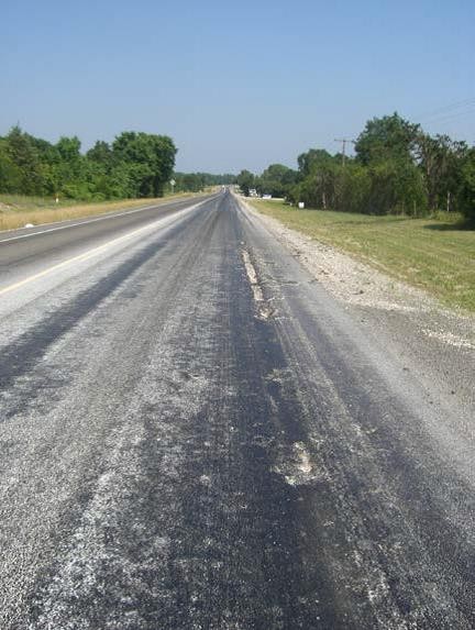 Potholes forming due to poorly bonded surfacetreatment. (click in image to see full-size image)
